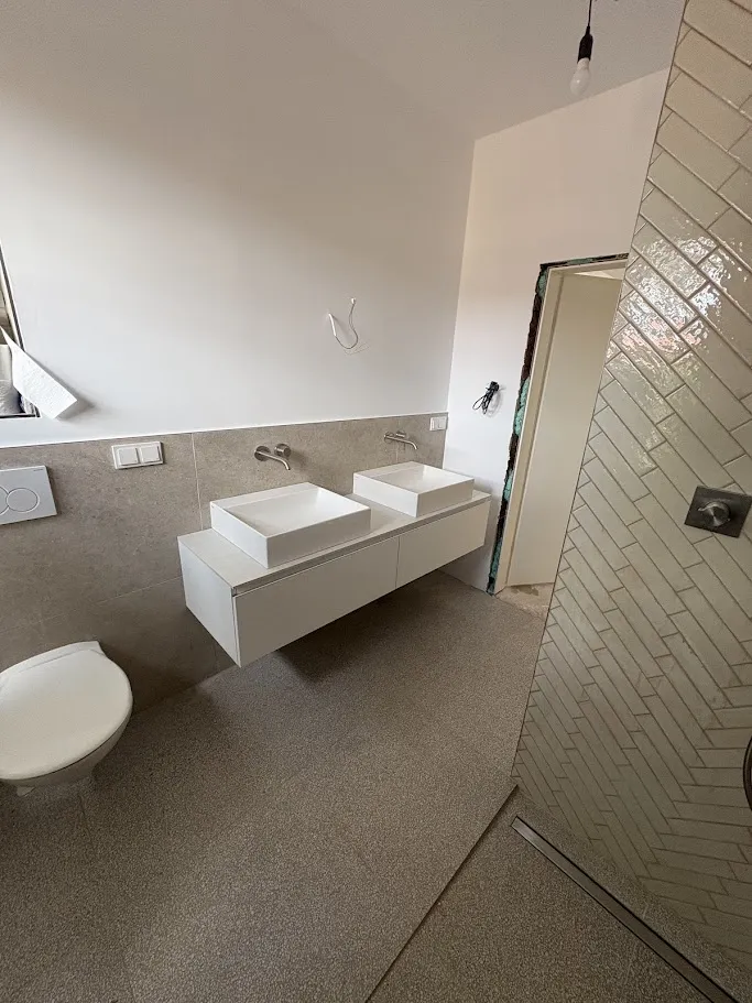 Badezimmer mit Doppelwaschbecken und Fischgrät-Fliesen